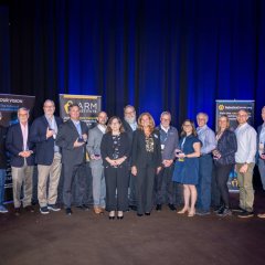 Photo of the ARM Institute's 2025 Class of Champions standing on stage with their awards