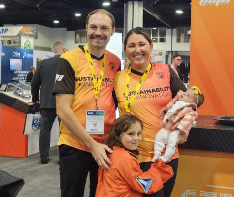 Photo of Haley Marie Keith standing with her husband and two daughters at a trade show