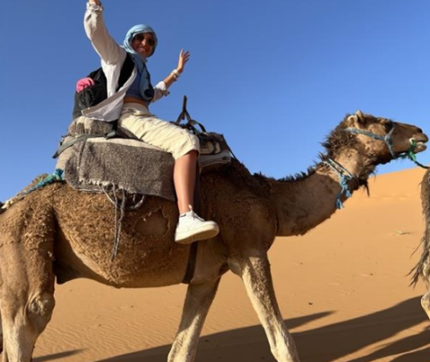 Photo of Lara Moreno Zepeda on a camel in the desert