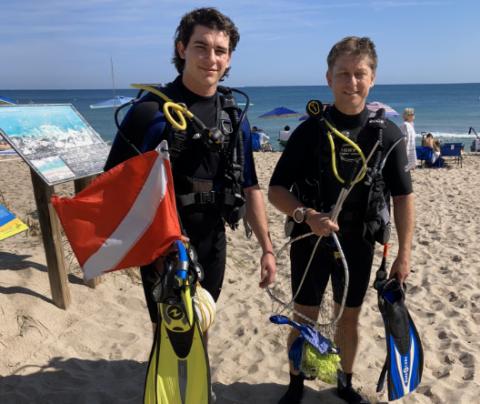 Photo of David Henshall with his sun on a beach in SCUBA gear